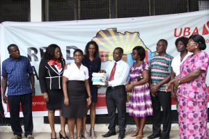 From (l-r) Mrs Abiola Bawuah, MD/CEO UBA Ghana, Madam Bola Atta presenting copies of the books to Assistant headmaster of Accra High School, Mr Addo