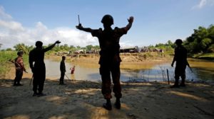 Members of Bangladesh's border guards gesture towards Rohingya stranded in the no man's land between the Myanmar and Bangladesh borders [Mohammad Ponir Hossain/Reuters]
